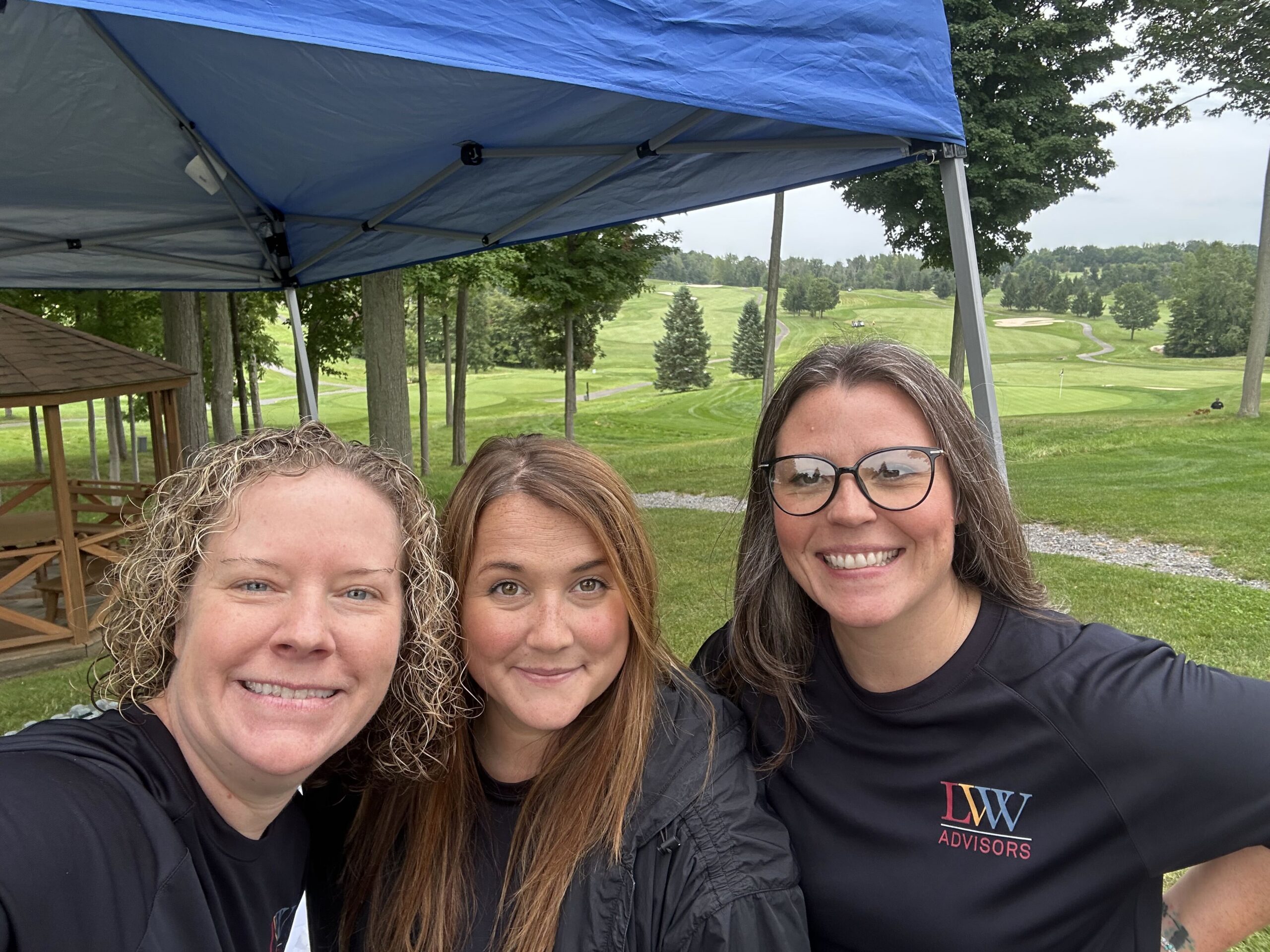Allie, Andrea, and Michelle posing for a photo in front of the LVW booth.
